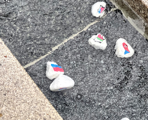 Steine mit Flaggen aus Europa im Brunnen