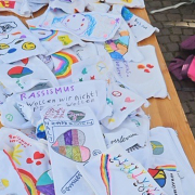 Viele von Kindern gemalte Bilder gegen Rassismus auf einem Tisch.