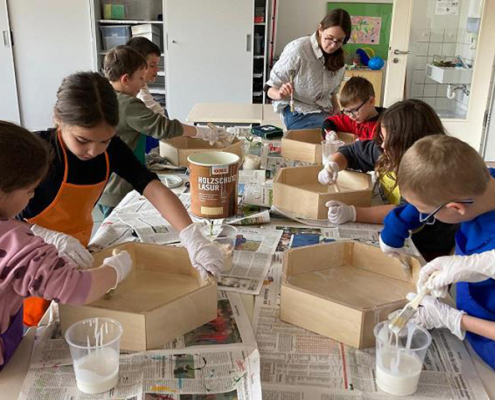 Garten-AG bei der Arbeit Kinder bearbeiten Holzkisten